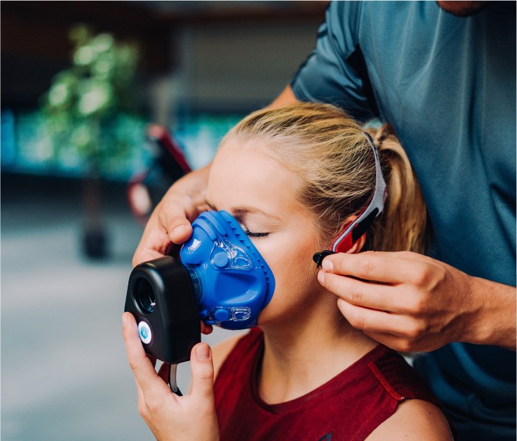 Spirometrie-Messung: Ein Mundstück zur Atemgasanalyse wird einer Klientin angepasst